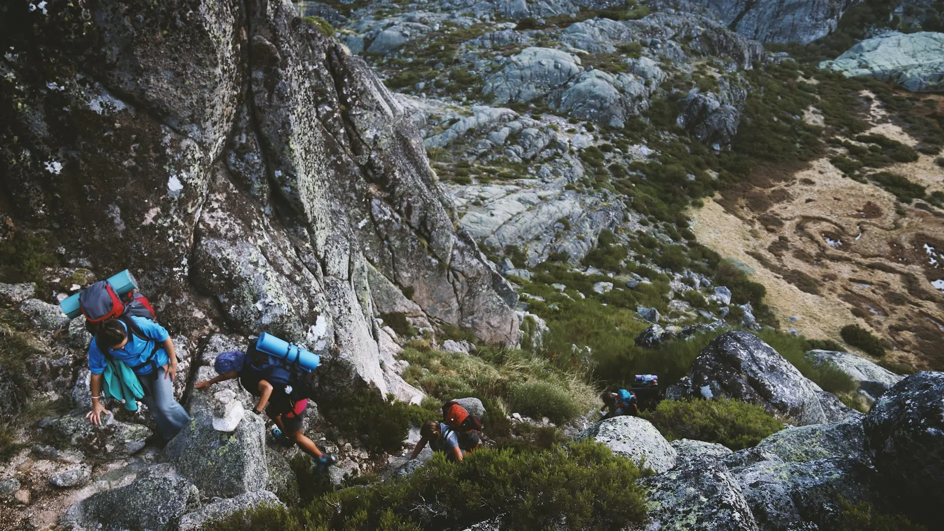 several mountain climbers on cliff of rock mountain at daytime